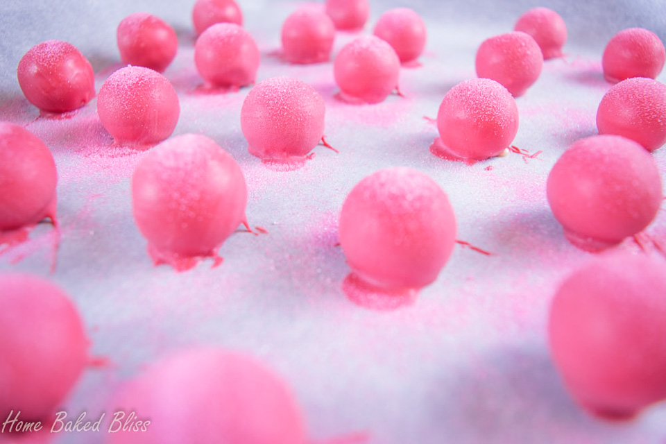 Sprinkling the rose water truffles with pink sanding sugar.
