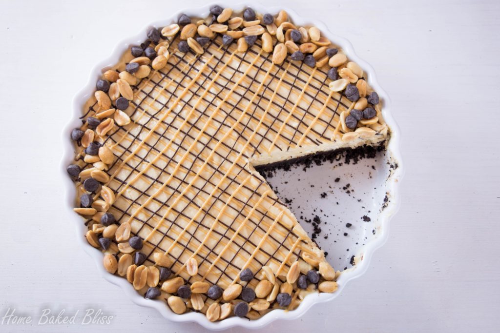 Chocolate peanut butter pie in a white pie pan with a slice cut out.