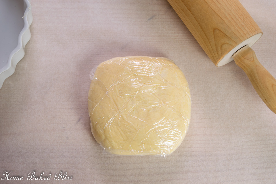 Wrapping dough disc in plastic wrap.