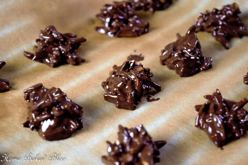Almond clusters cooling on a baking sheet.