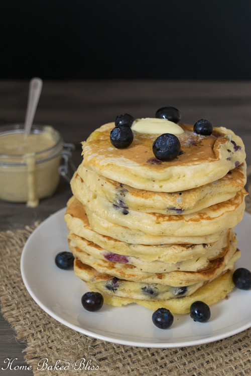 A stack of Blueberry Pancakes next to a jar of Homemade Vanilla Sauce