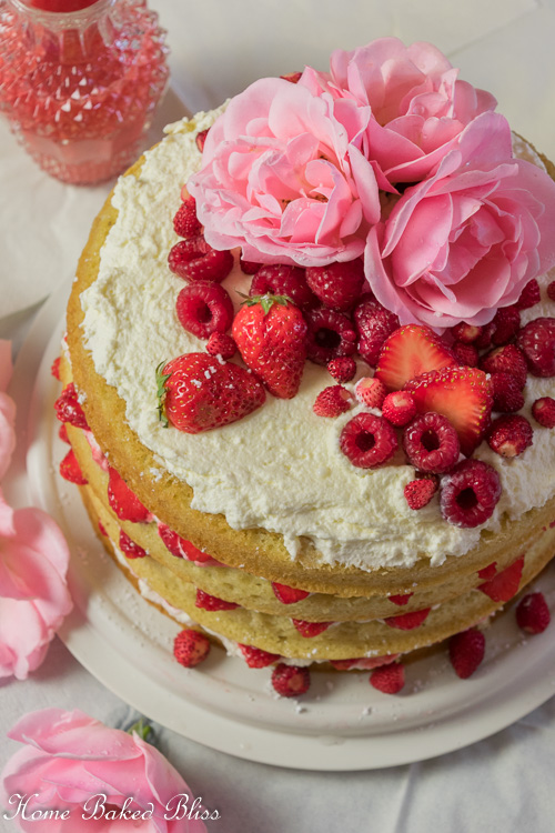 Berry Layer Cake garnished with fresh berries and roses