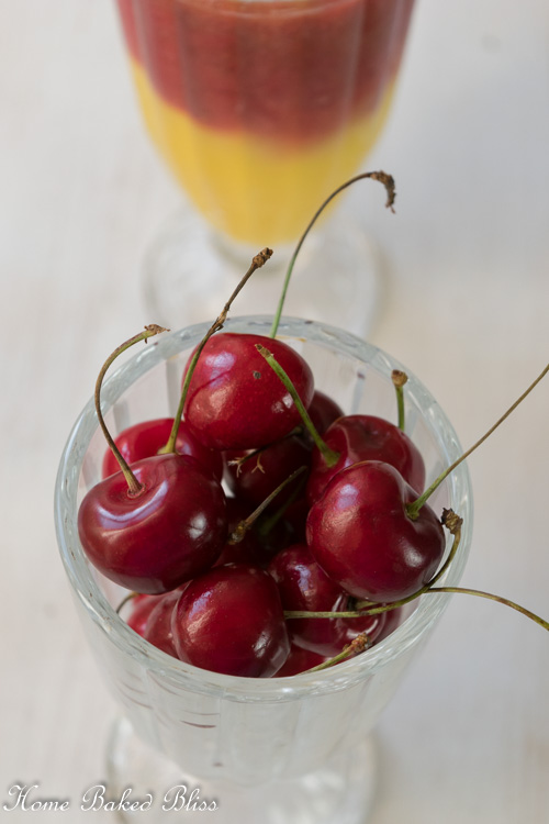 A tall glass full of fresh cherries.