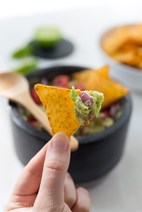 classic guacamole with tomatoes, red onions and chips
