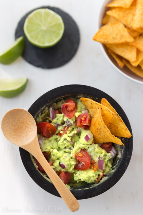 classic guacamole with tomatoes, red onions and chips