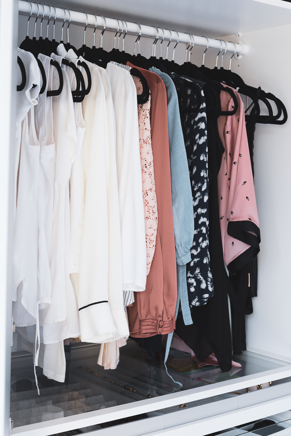 Clothes hung up and ordered by color