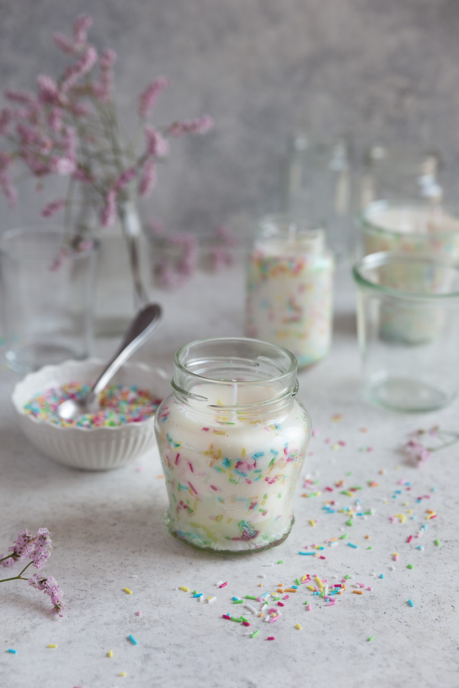 Three funfetti candles on a white surface