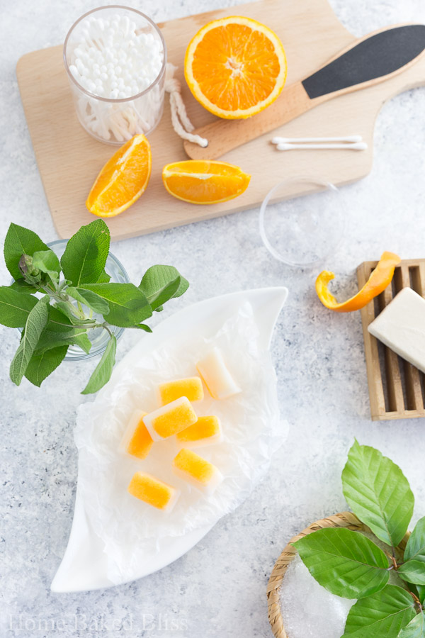 geschnittene Orange auf einem Holzbrett und einem Glass frischer Zitronenmelisse  