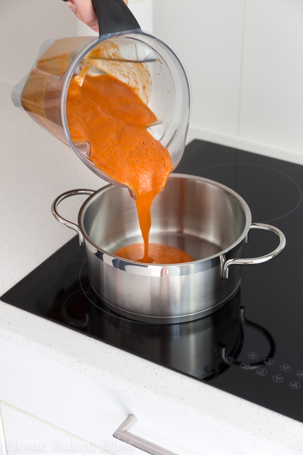 Pouring pureed apricots into a pot.