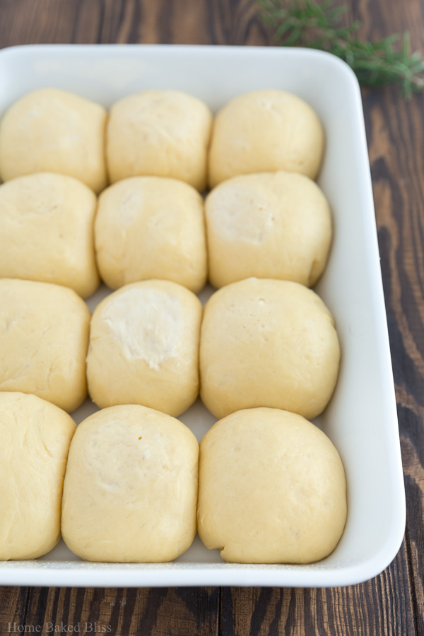 Dough balls in a white casserole pan.