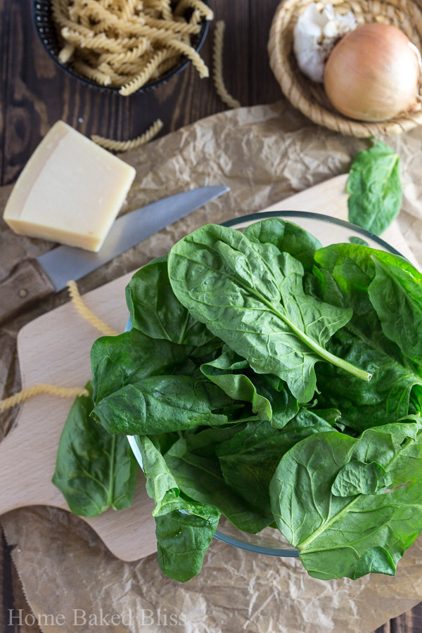 A glass bowl filled with fresh spinach.
