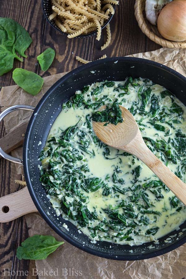 A black skillet filled with creamy spinach.