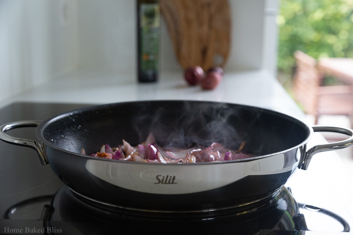Steaming balsamic glazed onions in a sauté pan.