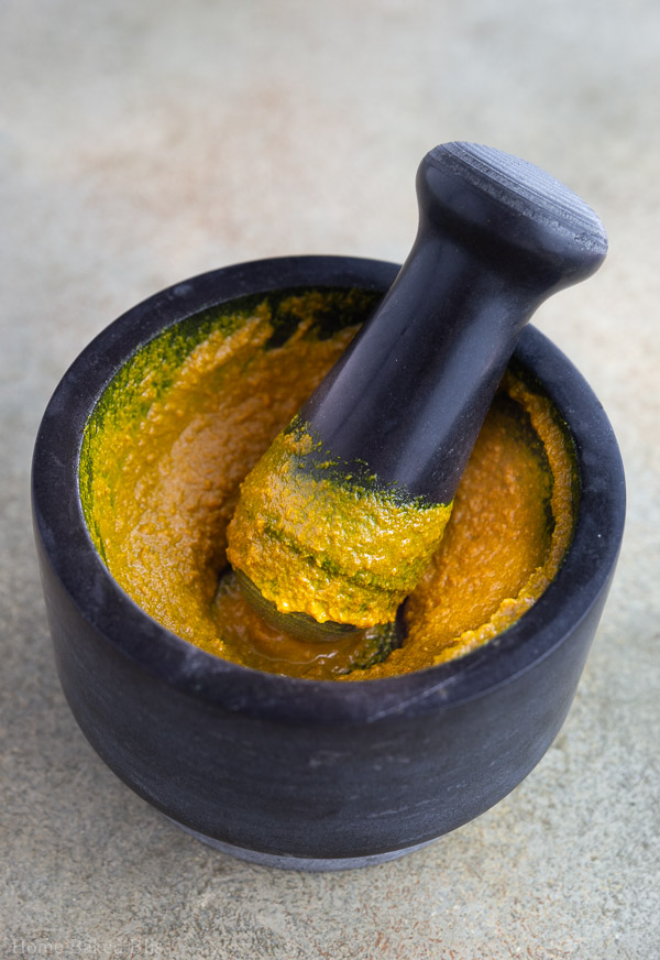 Grinding curry paste with pestle and mortar.