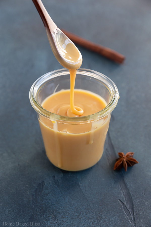 A drizzle of sweetened condensed milk on a wooden spoon.