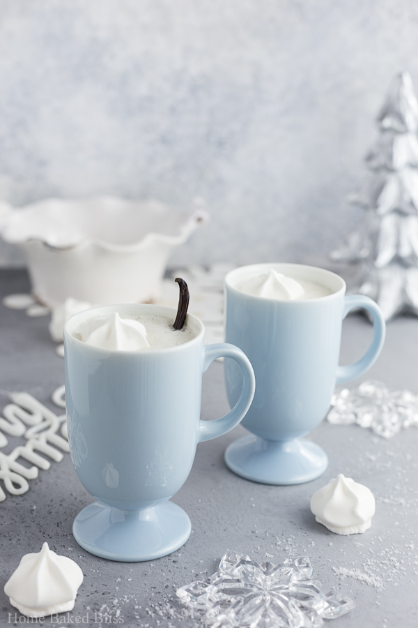Two light blue cups filled with warm vanilla milk.