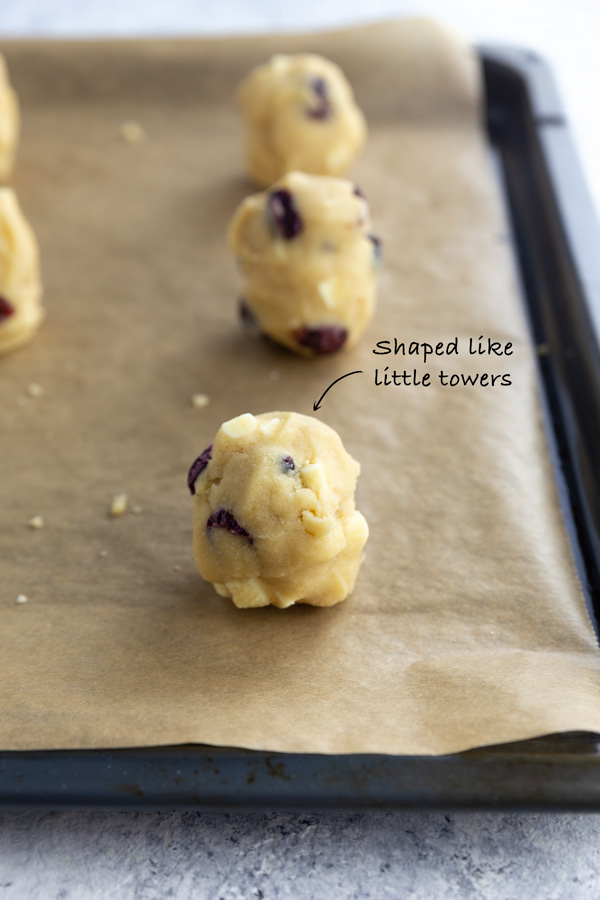 Little towers of cranberry white chocolate chip dough on parchment paper