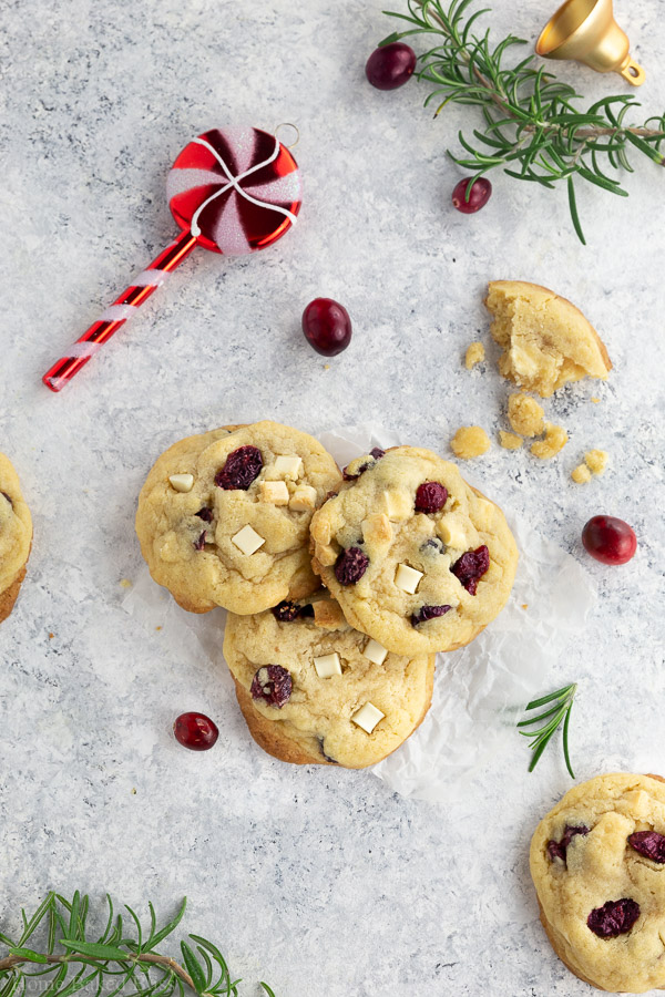 3 Cranberry white chocolate chips next a Christmas ornament and fresh cranberries.
