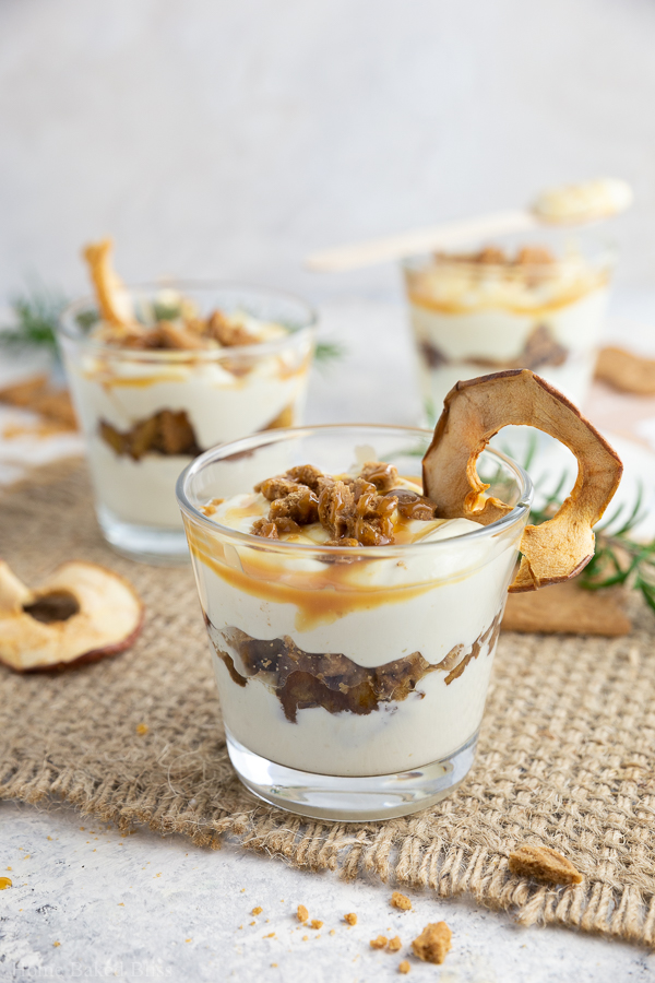 Speculoos tiramisu with cinnamon apples and caramel sauce in glasses.