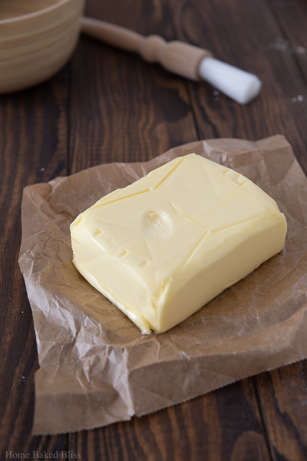 A block of butter with a fingerprint in it to show the butter is softened.