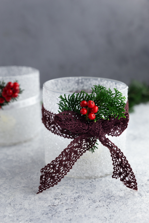 DIY Frosted Candle Jars with epsom salt, decorated with holly and purple ribbon