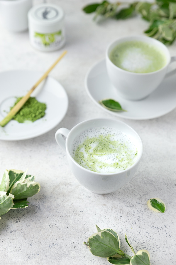 Frothy coconut matcha latte in a white mug