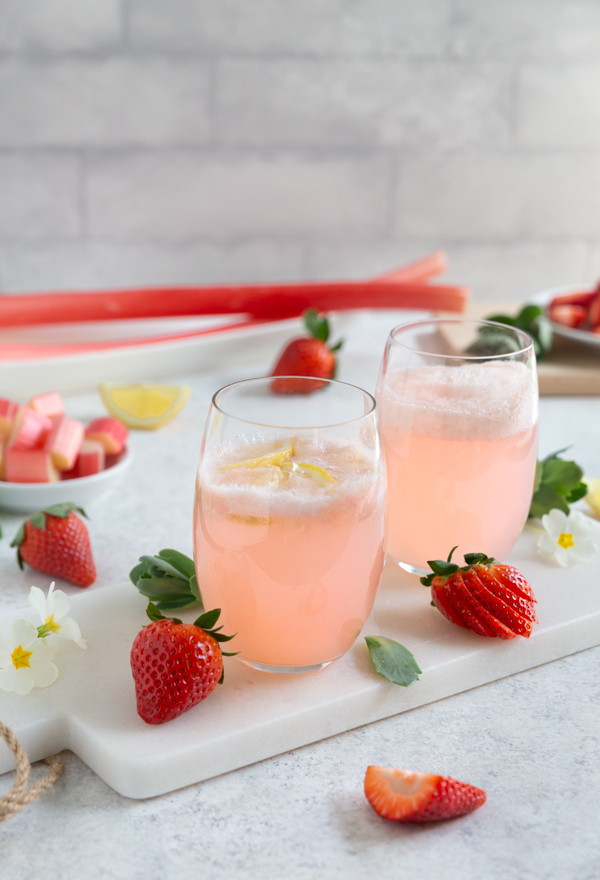 Two glasses of strawberry rhubarb lemonade on a white serving tray