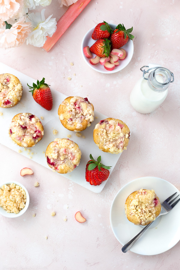 Strawberry Rhubarb Streusel Muffins on a pale pink background