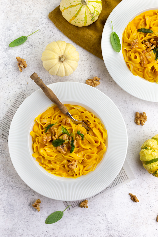 Creamy vegan pumpkin pasta with a wooden fork on the plate