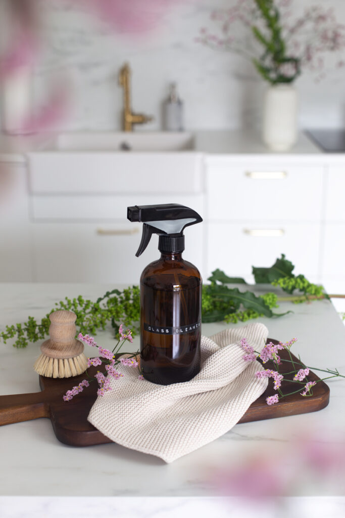 A brown bottle filled with DIY glass cleaner on a kitchen counter