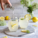 Pouring homemade lemonade into glasses