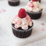 Closeup of Chocolate raspberry cupcakes on marble serving plate