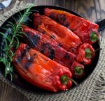 Grilled Peppers with Feta in a black pan with a twig of rosemary