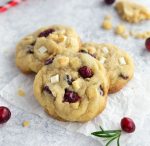 Cranberry white chocolate chip cookies on a white surface.