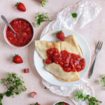 Vegan Crêpes with Strawberry Rhubarb Compote on a white plate