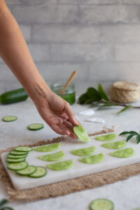 Laying cucumber eye pads onto a white tray