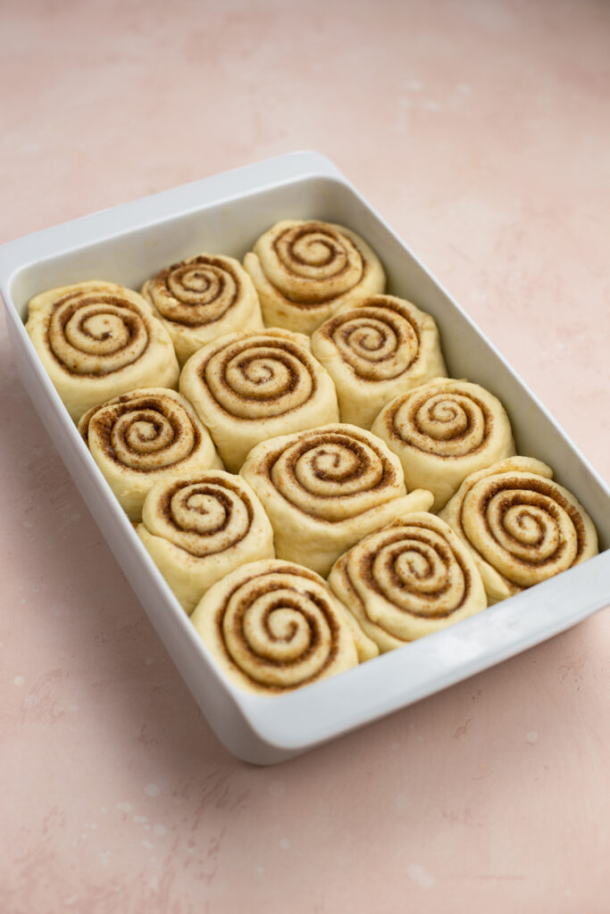 Vegan chai spiced rolls in a casserole pan after the second rise
