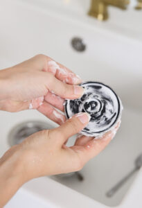 Spreading the DIY baking soda cleaning paste into the sink