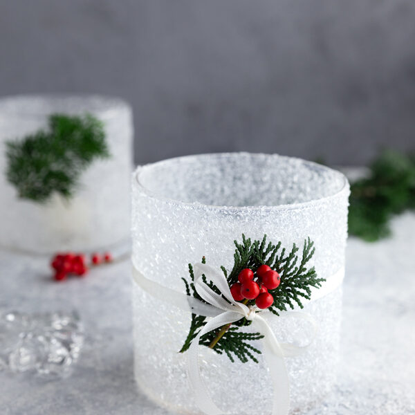 DIY frosted candle jar with epsom salt, decorated with holly and white ribbon