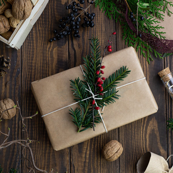 A small present wrapped in brown paper and decorated with holly